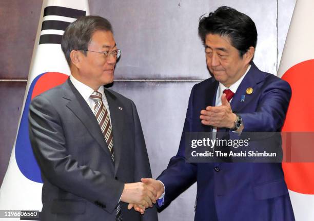 South Korean President Moon Jae-in and Japanese Prime Minister Shinzo Abe shake hands prior to their bilateral meeting on the sidelines of the South...