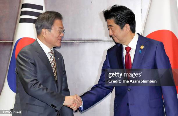 South Korean President Moon Jae-in and Japanese Prime Minister Shinzo Abe shake hands prior to their bilateral meeting on the sidelines of the South...