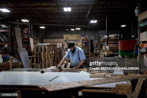 Worker cuts wood at Riverside RV, builders of recreational vehicles, on January 24, 2020 in LaGrange, Indiana. - The six or seven vehicles that come...