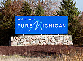Blue welcome to pure michigan sign on a stone wall