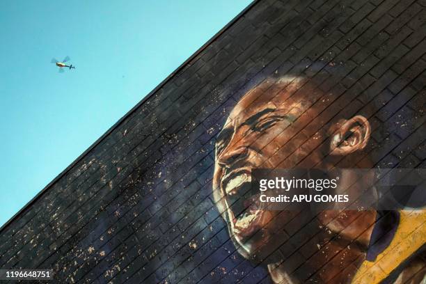 Helicopter flies over a Kobe Bryant mural in downtown Los Angeles on January 26, 2020. - Nine people were killed in the helicopter crash which...