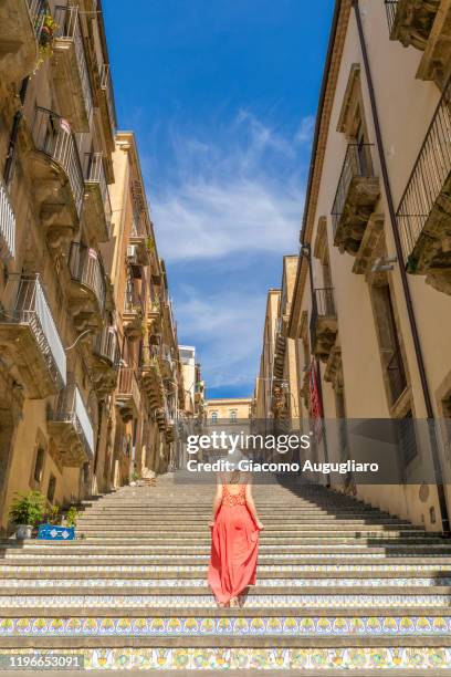 young woman admiring the staircase of caltagirone, catania province, sicily, italy - catania sicily fotografías e imágenes de stock