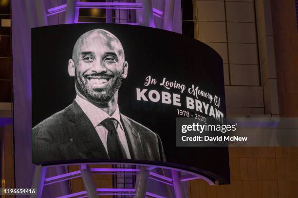 Memorial signage hangs near people mourning for former NBA star Kobe Bryant, who was killed in a helicopter crash in Calabasas, California, near...