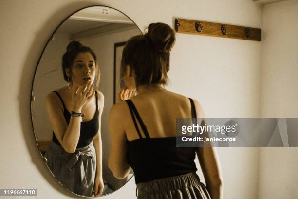 girl prepares to go out in front of the mirror - mirror imagens e fotografias de stock
