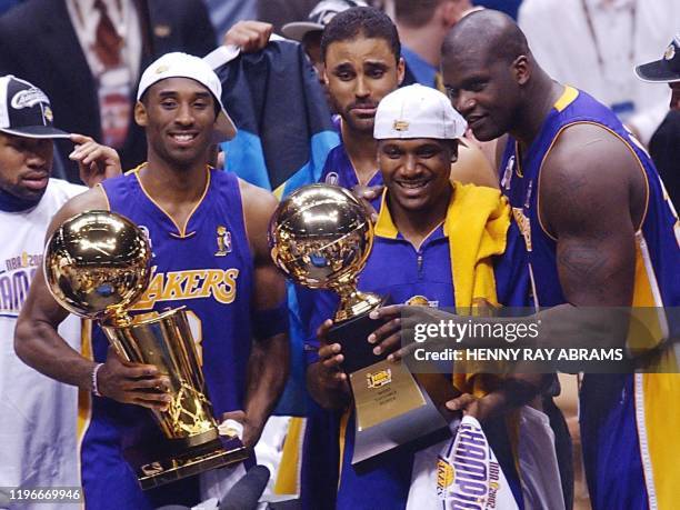 Los Angeles Lakers Kobe Bryant , Rick Fox , Linsey Hunter and Shaquille O'Neal stand with the championship and MVP trophies after game four of the...