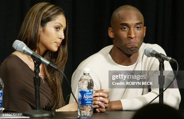 Los Angeles Lakers star Kobe Bryant clasps hands with his wife Vanessa Bryant as Kobe admits to adultery but not sexual assault in response to the...