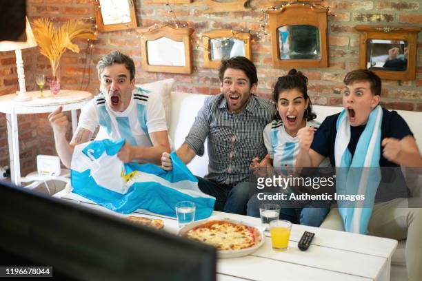 argentinian soccer fans  cheerful, screaming eating takeaway pizza  and looking soccer play - argentina food imagens e fotografias de stock