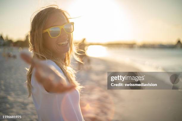 suivez-moi à, jeune femme menant petit ami à la plage au coucher du soleil, mexique - follow me to man photos et images de collection