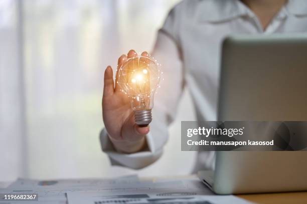 hand of businessman holding illuminated light bulb, idea, innovation and inspiration concept. - hände glühlampe stock-fotos und bilder