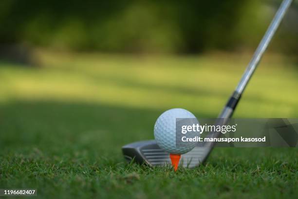 golf ball on green grass ready to be struck on golf course background - golf swing close up stock pictures, royalty-free photos & images