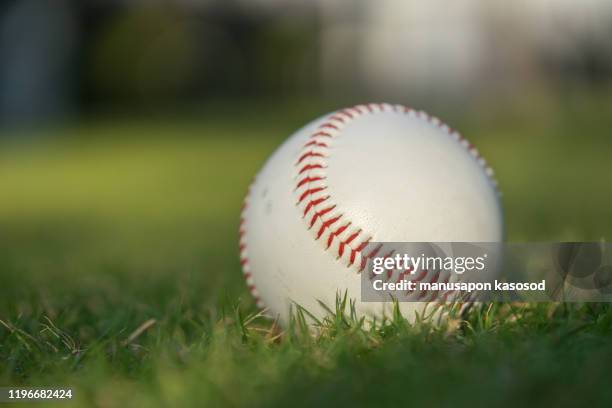 baseball ball on the green lawn - baseball fields stock-fotos und bilder