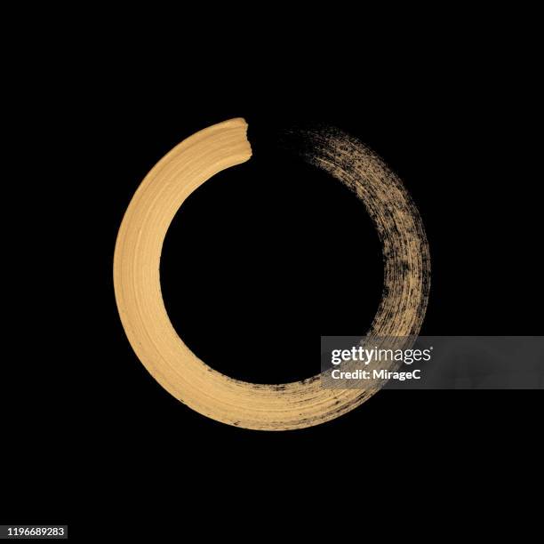 gold colored sumi circle on black - brush circle stock pictures, royalty-free photos & images