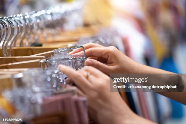 buy clothes,ooking for brightly colored clothes on hangers, choose to buy clothes. - outlet stockfoto's en -beelden