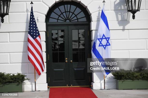 The flags of Israel and the US are seen before US President Donald Trump greets Israeli Prime Minister Benjamin Netanyahu as he arrives for meeting...
