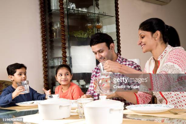 family having lunch at home - south asian family eating stock pictures, royalty-free photos & images