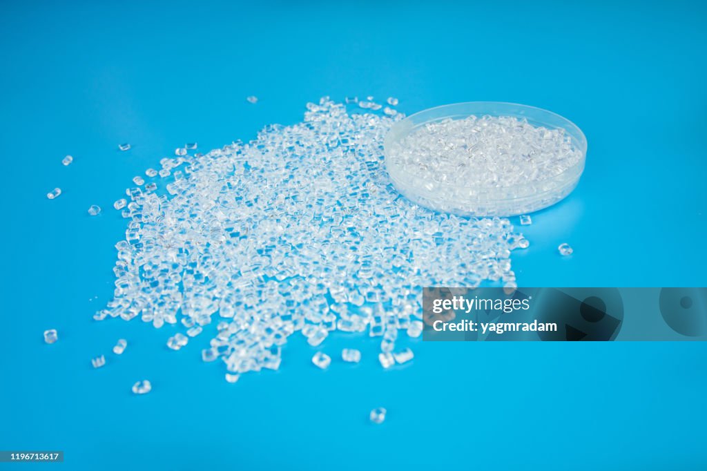 Transparent Polypropylene, polypropene, polystyrene, polyethylene, thermoplastic polymer, HDPE and plastic raw material pellets or granules on isolated blue background