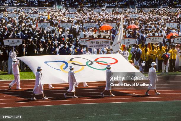The Olympic Flag is carried into the stadium during the Opening Ceremony of the 1988 Olympic Games on September 17, 1988 at the Jamsil Olympic...