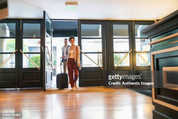young business people entering the hotel - hotel entrance stock pictures, royalty-free photos & images