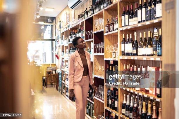 businesswoman searching for a wine - liquor store interior stock pictures, royalty-free photos & images