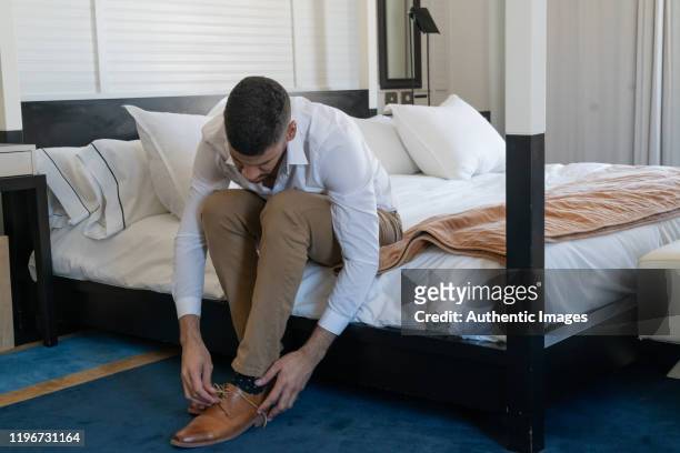 young businessman tying his shoes in the hotel room - leather shoe stock pictures, royalty-free photos & images