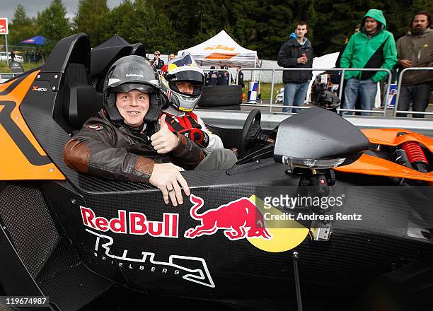 Moderator and comedian Guido Cantz and DTM driver Martin Tomczyk attend the Red Bull On Track event at the Driving Safety Center on July 23, 2011 in...