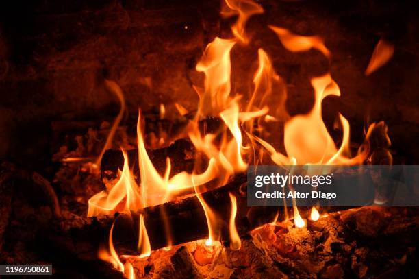 flames of fire are consuming the logs of oak wood which is burning in the fireplace. - warming up 個照片及圖片檔