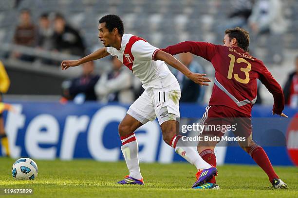 Luis Seijas of Venezuela struggles for the ball with Carlos Labaton of Peru during the Copa America 2011 third place match between Venezuela and Peru...