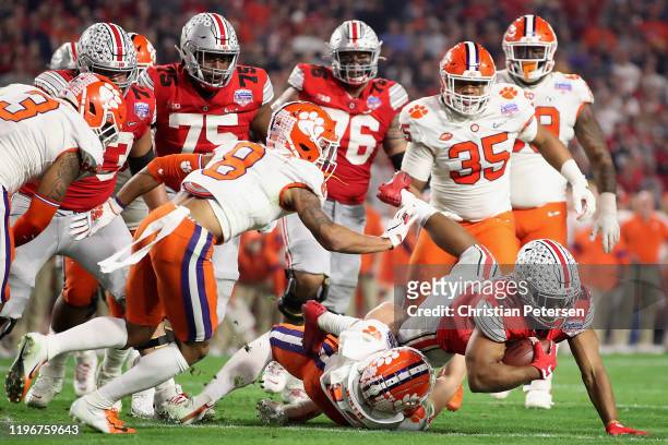 Running back J.K. Dobbins of the Ohio State Buckeyes rushes the football against the Clemson Tigers during the PlayStation Fiesta Bowl at State Farm...
