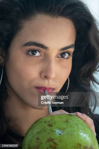 drinking coconut water with straw made of metal - coconut water stock pictures, royalty-free photos & images