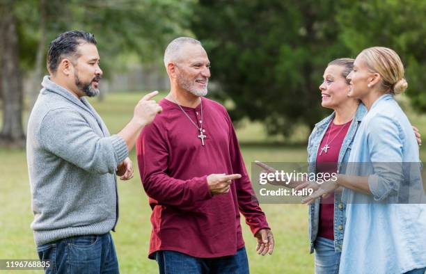 two hispanic couples, friends and family talking at park - paparazzi x posed stock pictures, royalty-free photos & images