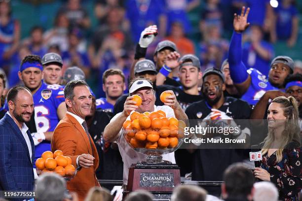 Head Coach Dan Mullen of the Florida Gators throws oranges to the players after winning the Capital One Orange Bowl against the Virginia Cavaliers at...