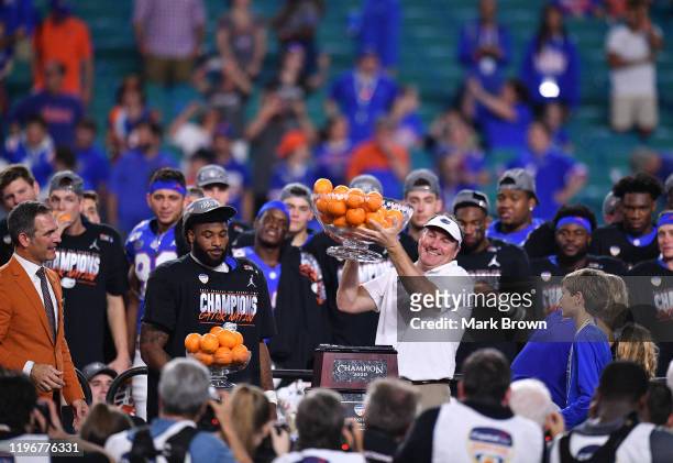 Head Coach Dan Mullen of the Florida Gators raises the Orange Bowl Trophy after winning the Capital One Orange Bowl against the Virginia Cavaliers at...
