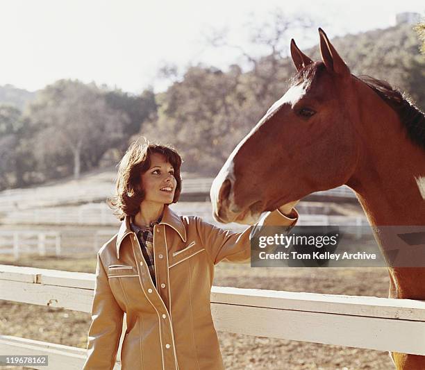 woman stroking horse beside fence - 1970 stock pictures, royalty-free photos & images