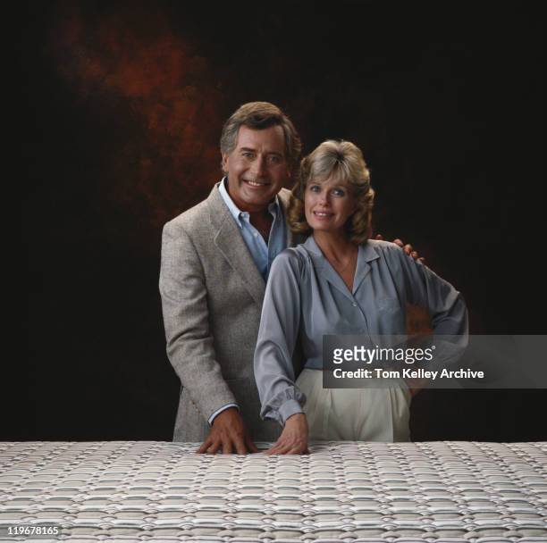 coppia matura in piedi contro sfondo nero, sorridente, portra - anno 1980 foto e immagini stock