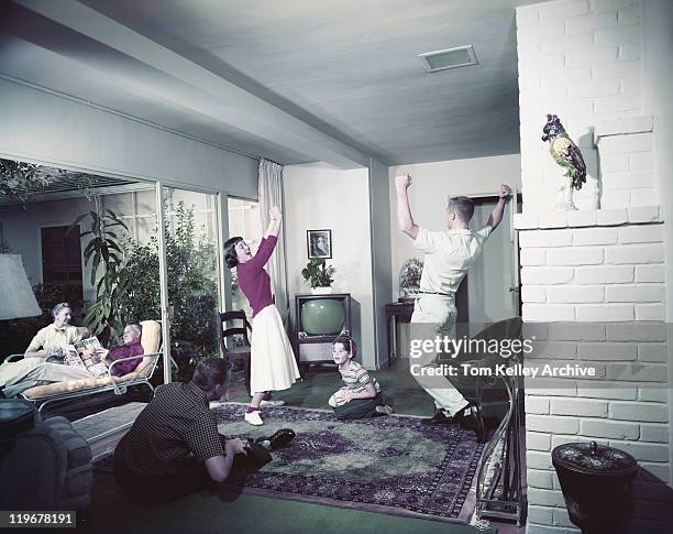 family enjoying in living room - 50s tv family stock-fotos und bilder