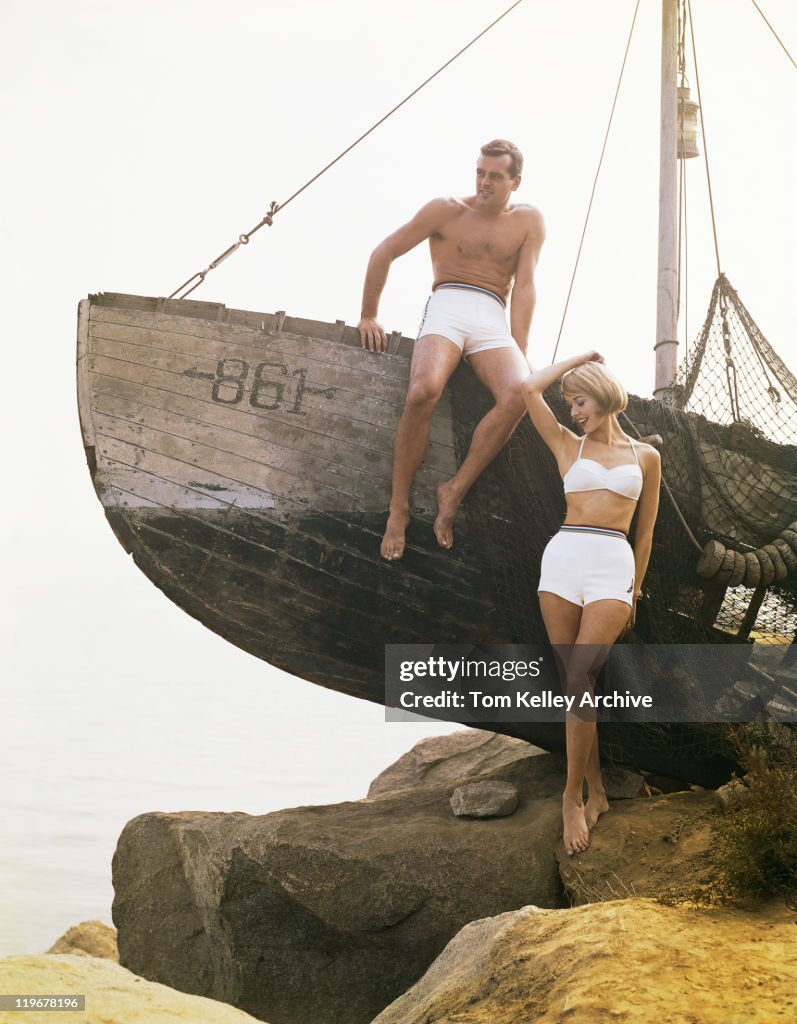 Man sitting boat, woman standing beside