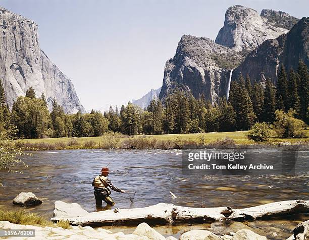 mann angeln in riverside mit den bergen im hintergrund - 1950 1959 stock-fotos und bilder