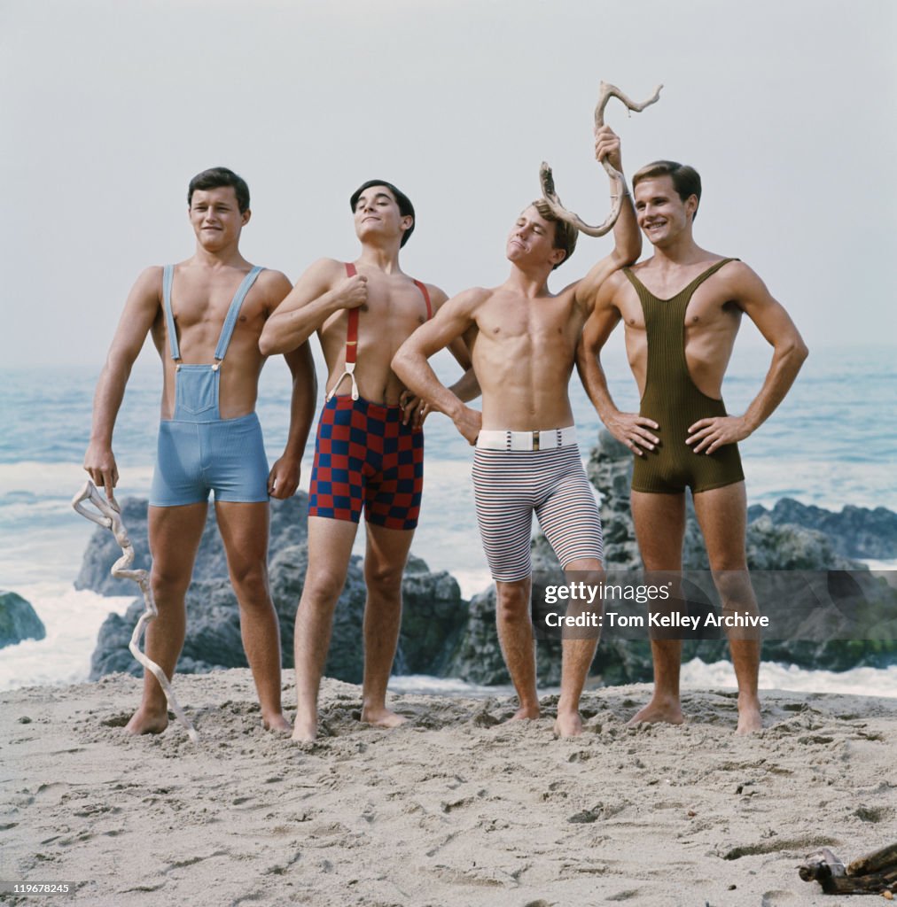 Friends standing on beach, smiling