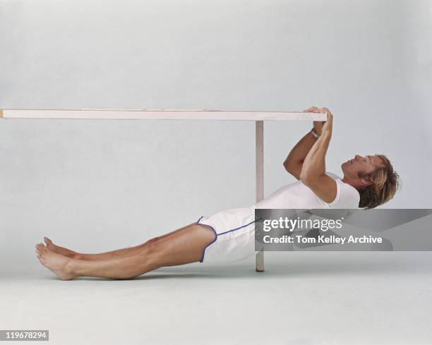 man stretching and exercising on balance beam - 1975 - fotografias e filmes do acervo