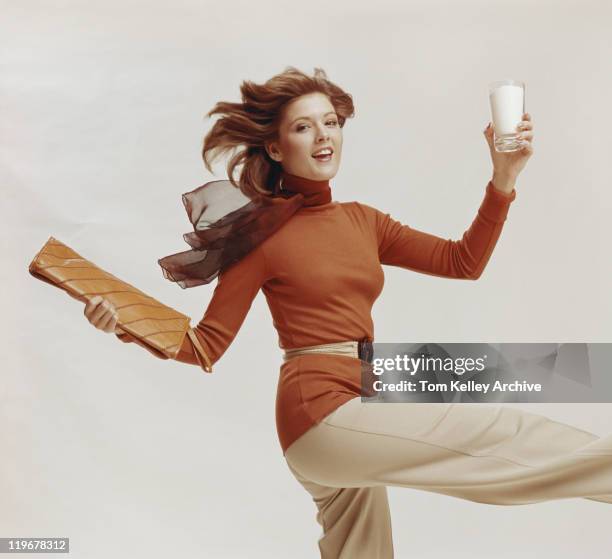 woman holding glass of milk and file, smiling, portrait - archival woman stock pictures, royalty-free photos & images