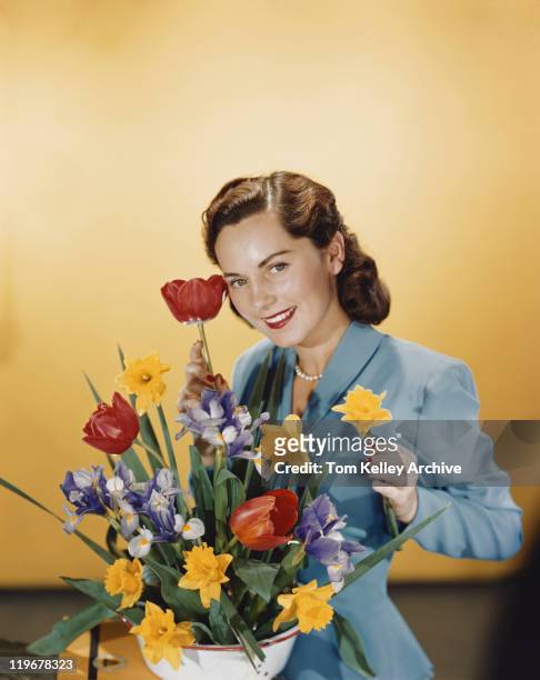 junge frau arrangieren blumen, lächeln, porträt - woman 1950 stock-fotos und bilder