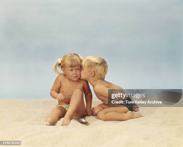 boy kissing girl on beach - kids in undies stockfoto's en -beelden