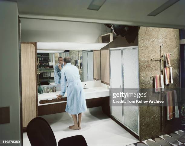 uomo radersi di fronte allo specchio in bagno - anno 1959 foto e immagini stock