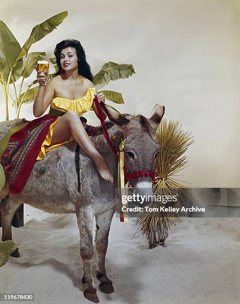 young woman sitting on donkey holding beer glass, smiling, portrait - 1960 stock pictures, royalty-free photos & images