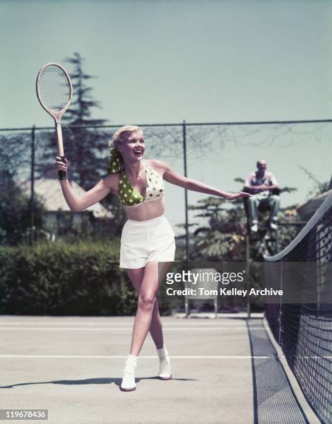 young woman playing tennis, smiling - 1960 stockfoto's en -beelden