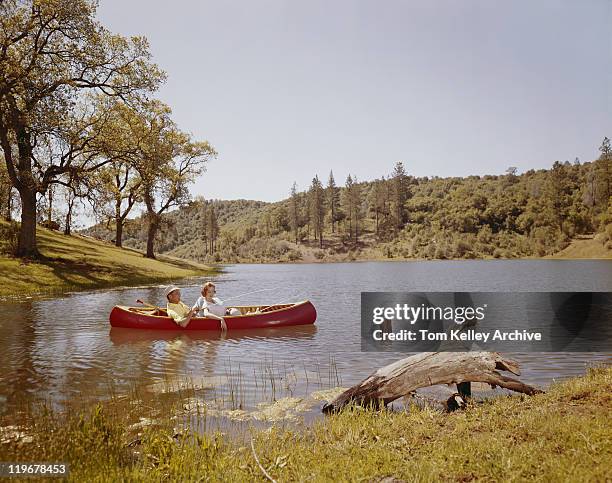 couple fishing from canoe in lake  - 1960 stockfoto's en -beelden
