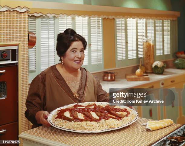 mature woman holding meat in plate, smiling, portrait - 1961 stock pictures, royalty-free photos & images