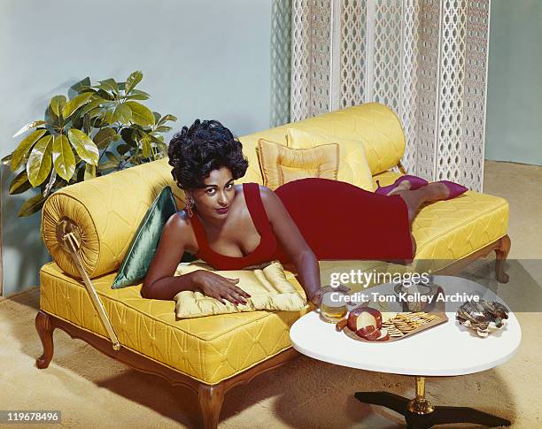 young woman lying en el sofá con refrigerios en la tabla, de retratos - 1962 fotografías e imágenes de stock