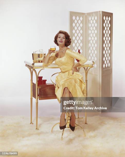 young woman sitting on chair holding beer glass with screen partition in background - 1962 bildbanksfoton och bilder