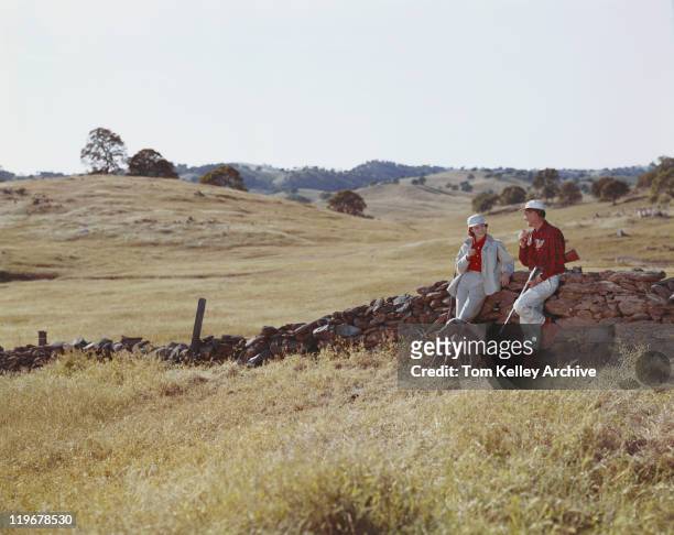 couple standing by stone wall with dog - hunting sport stock pictures, royalty-free photos & images